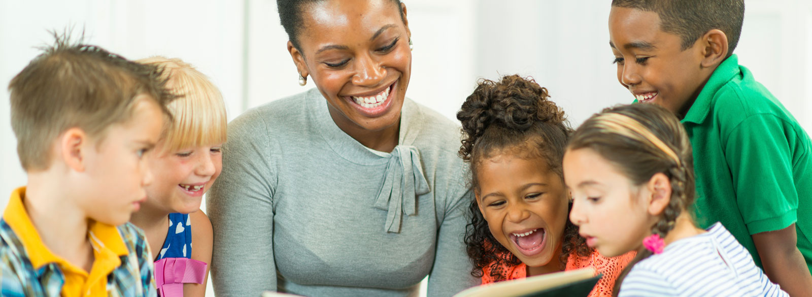 Preschool-age children reading with a teacher